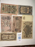 Top view of seven assorted Russian paper rubles from early 1900s showing various denominations, dates and designs.