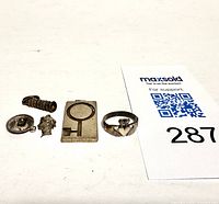 All five items laid out including four charms and one ring, showing size and detail.