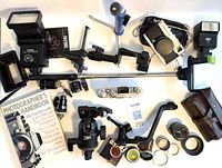 Overhead view showing flash units, cameras, monopod, tripod head, filters, mounts and book