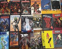Top view of the comic books arranged in rows showing cover art including Deadpool, X-Men, Captain America, Sin City A Dame to Kill For, Hellboy, and Watchmen.