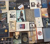 Top-down image showing many books arranged tightly side by side and some stacked, with visible titles and authors.