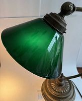 Close-up of the green glass lampshade showing the color and glass occlusions.