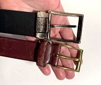 Photo showing black and warm brown leather belts held together to display belt buckles.