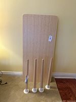 Full view of bamboo desktop leaning against wall with four bamboo legs standing in front.