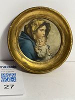Front view of round gold-coloured frame with Madonna and Child print inside, showing detailed artwork of woman and child.