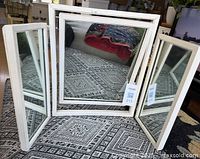 Front view of the off-white three-panel tabletop vanity mirror showing center and side panels unfolded with visible hinges.