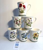 Photo showing all six Portmeirion Botanic Garden mugs stacked in a pyramid shape with various flower designs visible.