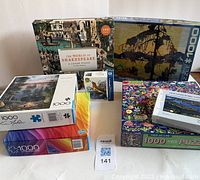 Photo showing all seven puzzles stacked and arranged with varying box designs visible, including Shakespeare, birds, flora and ship themes.