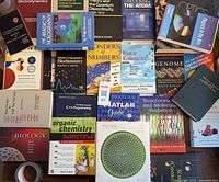 Overhead view of the science books spread out, showing titles on biology, chemistry, physics, mathematics, and computing.