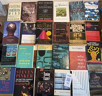 Spread of all 25 books visible laid out flat on table with front covers facing up.