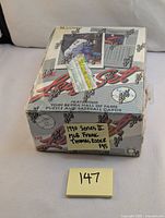 Front angled view of sealed 1990 Leaf Series 2 baseball card box set with visible wear and sticker on front.