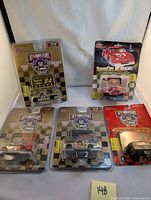Five sealed NASCAR diecast cars displayed in original packaging, including 50th Anniversary Pewter Edition and Stock Car NASCAR.