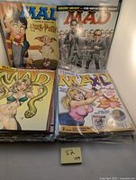 Front view of several MAD magazine covers includes covers parodying Harry Potter and The Matrix.