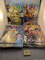 Front view of four Mad Magazines in plastic sleeves, showing Shrek, Fantastic Four, Grand Theft Auto, The Incredibles cover parodies.