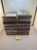 Two stacks of 42 classic rock CDs in jewel cases, arranged vertically showing album spines clearly.