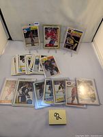 Overall display of multiple hockey cards laid out, some encased in protective sleeves and some loose, including various NHL teams and players mainly from the 1980s.