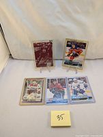 Front view of five hockey cards displayed on stands: Andrea Cogliano printing plate card (burgundy), Warren Foegele Marquee Rookie, Matthew Tkachuk Top Rookie, Zach Hyman Young Guns, and another card.