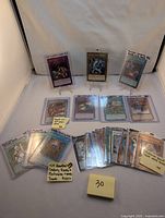 Overview of the 25 Yu-Gi-Oh cards spread on a table including some sleeved rares and a handwritten note showing the card count and rarity types included