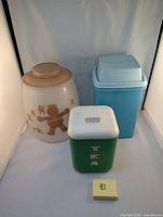 Photo of three kitchen containers including large gingerbread man cookie jar, tea container, and pickle keeper