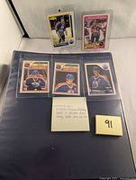 Five Wayne Gretzky hockey cards in protective sleeves and sleeves with 91 post-it note label. Included cards are 1980s style with Gretzky in Edmonton Oilers uniform.
