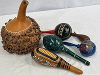 Overall view of all six indigenous percussion instruments showing large gourd shekere and five wooden maracas/rattles