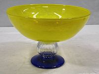 Side view of the art glass fruit bowl showing yellow bowl and cobalt blue pedestal base