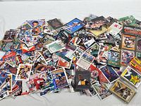 Photo showing a large unsorted pile of mixed sports trading cards of football, baseball, basketball, and other players.