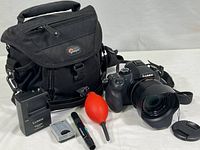 Overall view showing camera, charger, battery, cleaning tools, and Lowepro bag
