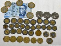 Mixed coins and bills on white background including Mexican pesos, Euros, Netherlands coin, and 20 peso banknote.