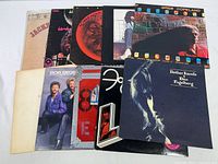 Photo displaying all 10 rock vinyl albums stacked showing partial covers and titles.