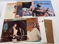 Eight vintage vinyl albums laid out on a white surface showing cover art.