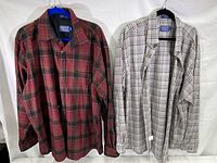 Both Pendleton shirts side by side, showcasing red/black and white/gray plaid patterns