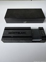 Black glossy Montblanc fountain pen case with sliding drawer and Montblanc logo on top.