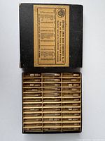 Top-down photo of Gunther's Swiss Hand Assortment No. 45 box open, showing multiple compartments holding small tubes with vintage pocket watch hands.
