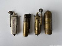Photo showing all four vintage WW2 lighters arranged side-by-side.