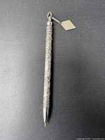 Full view of the vintage sterling silver pen showing intricate 12 Tribes of Israel engravings along the body and diamond-shaped tag on a spring loop at the top.