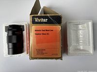 Photo of lens packaged in white foam inserts with original box marked Vivitar Automatic Fixed Mount Lens Telephoto 135mm f3.5