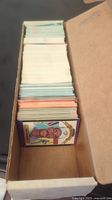 View from top of a box of assorted baseball cards showing a thick stack with a card featuring Orlando Cepeda on top in purple-bordered Donruss design.