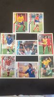 Full view of all eight 1994 Upper Deck World Cup soccer cards laid out on black background.