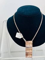 Front view of sterling silver necklace on black display bust showing full necklace and pendant.