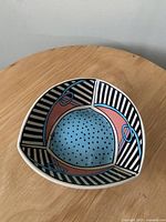 Top view of the triangular bowl showing full interior colorful geometric design featuring blue, pink, black and white stripes.
