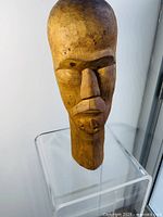 Front view of the carved wooden African head statue showing facial features and texture.