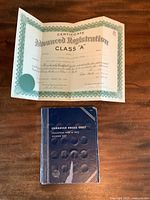 Full view of certificate and penny collection album on table.