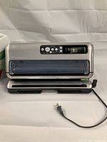 FoodSaver vacuum sealer showing front and top panel with control buttons and sealing area.
