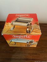 Closed original red Imperia box displaying the pasta machine model and branding.