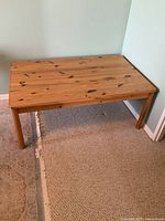 Full view of the pine wood coffee table showing the overall condition and shape.