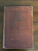 Front cover of the book showing weathered reddish-brown cloth with faded imprint, corners slightly worn.