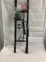 Photo showing the assembled parts of the black metal pull up bar with foam grips, partially wrapped in plastic tape.