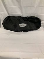 Black Wintertek branded carrying case for snowshoes, lying on a white surface