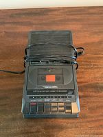 Front view of the Realistic GTR-73 cassette recorder/player with cassette loaded and power cord wrapped around.